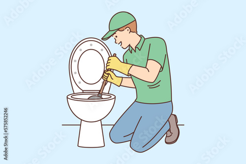Plumber is repairing toilet bowl using plunger to clean pipes after clogged sewer