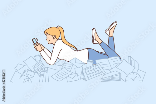 Procrastination woman with phone lies on documents and stationery oblivious to mess