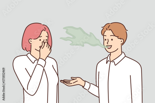 Woman covers nose with hand, feels discomfort communicating with man due to bad breath