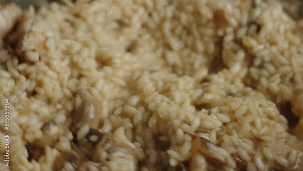 Process of cooking risotto with mushrooms. Arborio rice boiled in frying pan in home kitchen, close up. Italian cuisine dish Process of cooking risotto with mushrooms. Arborio rice boiled in frying pan in home kitchen, close up. Italian cuisine dish