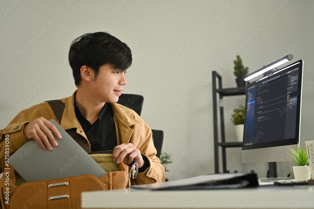 Asian male programmer sitting front of computers with coded data on ...