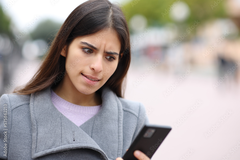 Angry woman checks phone in winter