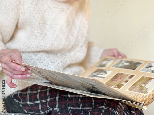 白黒セピア写真のアルバムを見る高齢女性の手