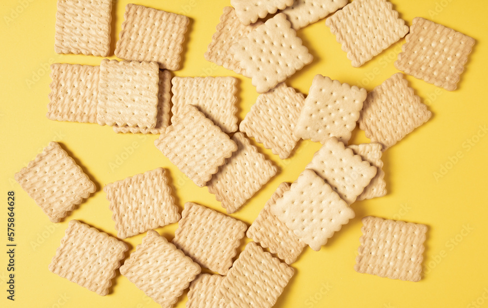 A pile of crackers carelessly scattered on a yellow background close-up A pile of crackers carelessly scattered on a yellow background close-up