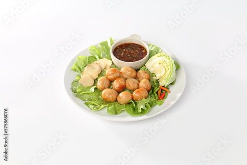 Thai sausage or Isan sausage (grilled fermented rice with minced pork), with fresh cabbage, ginger, and chili peppers, on a white plate.