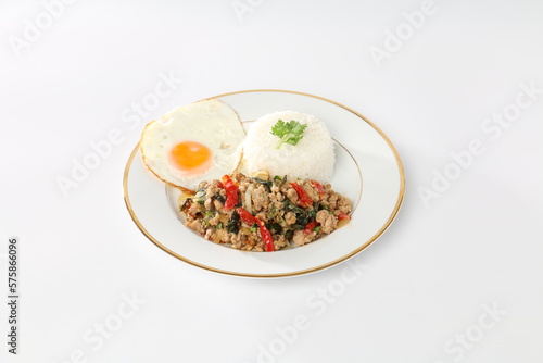 Rice topped with stir-fried minced pork and holy basil, fried egg, and white background.