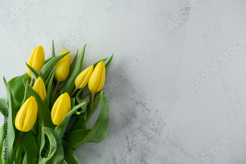 Yellow tulips flowers for Women's Day, Mother's Day, birthday, wedding anniversary or marriage proposal engagement. Floral arrangement flat lay composition with copy space.