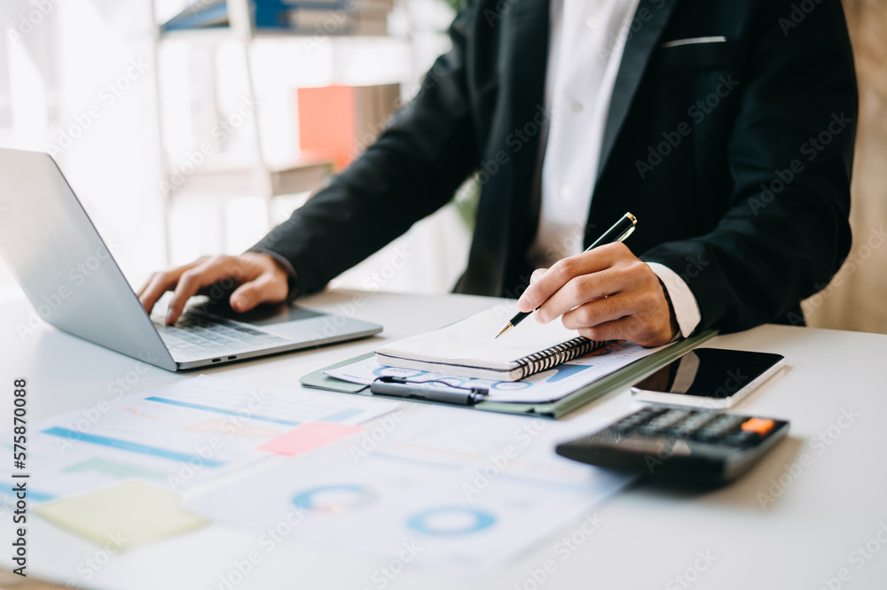 business documents on office table with smart phone and digital tablet and graph financial and woman working at office. business documents on office table with smart phone and digital tablet and graph financial and woman working at office.