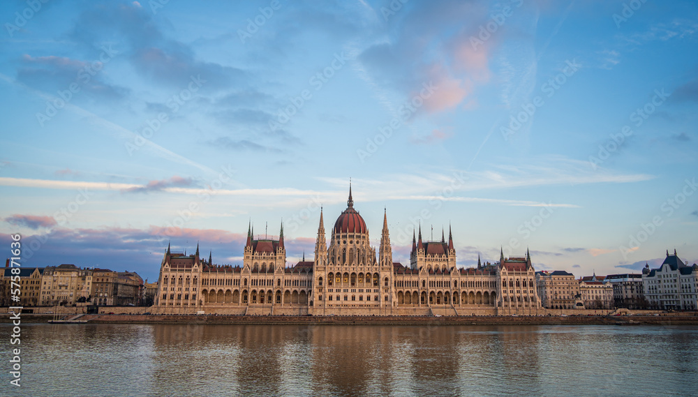 Panoramic view of Budapest Parliament from across Danube river, Hungary. Beautiful blue evening sky with pink clouds.