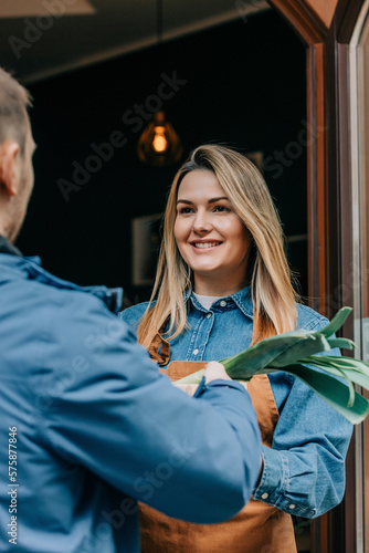 Wallpaper Mural Young smiling owner receiving vegetables from delivery person Torontodigital.ca