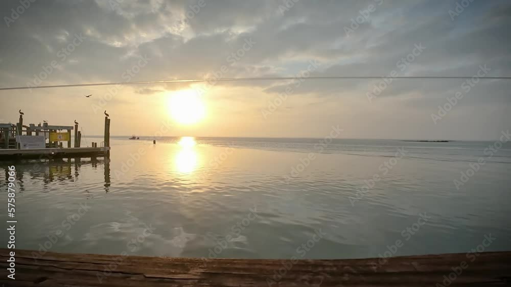 Time lapse of a tranquil sunset over a pier on Laguna Madra near Corpus Christi, Texas; concepts of tourism, tranquility Time lapse of a tranquil sunset over a pier on Laguna Madra near Corpus Christi, Texas; concepts of tourism, tranquility