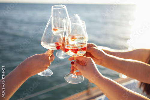 Sunset sky and sea on the background. Making a celebratory toast with sparkling wine