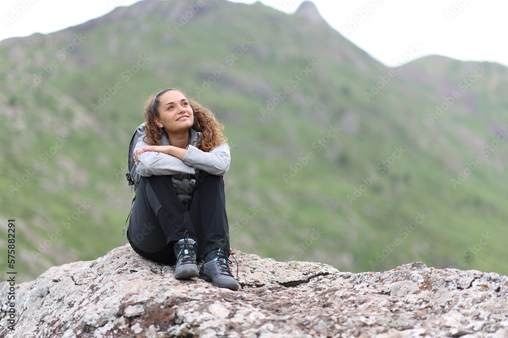 Naklejka premium Happy hiker sitting on a rock contemplating views