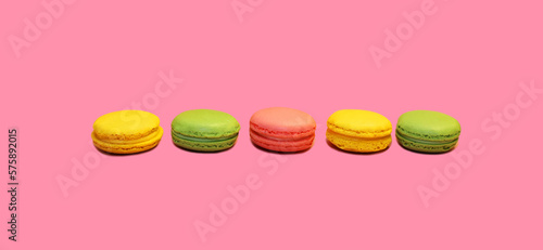 Multicolored sweet macaroons on pink background