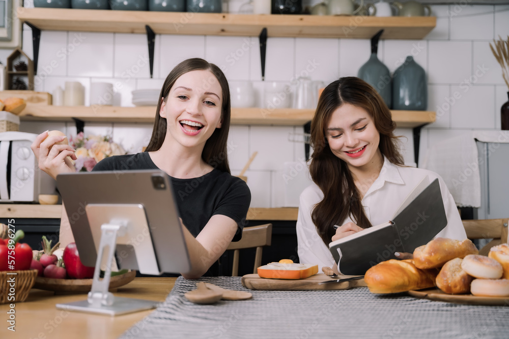 Woman jotting down bread recipe through tablet. Woman jotting down bread recipe through tablet.