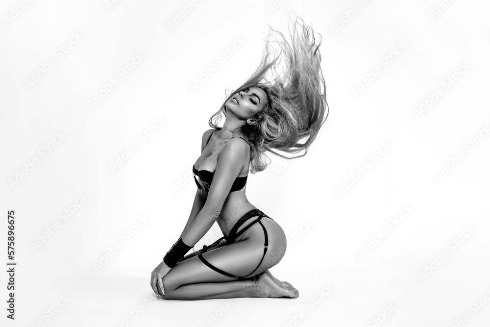 Beautiful sexy blonde woman in latex erotic lingerie on a white background in studio. Hot model. Black and white art photo. - obrazy, fototapety, plakaty 