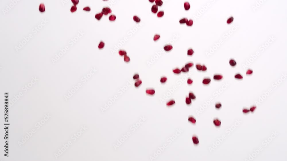 Red pomegranate arils falling in slow motion on white studio backdrop in 4k Red pomegranate arils falling in slow motion on white studio backdrop in 4k
