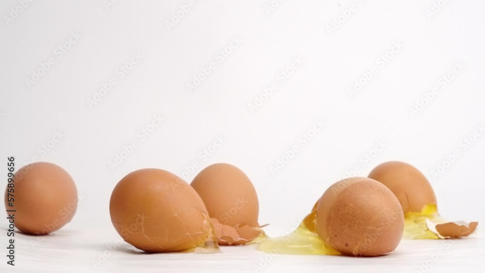 Brown eggs dropped and breaking on white studio backdrop in 4k slow motion Brown eggs dropped and breaking on white studio backdrop in 4k slow motion
