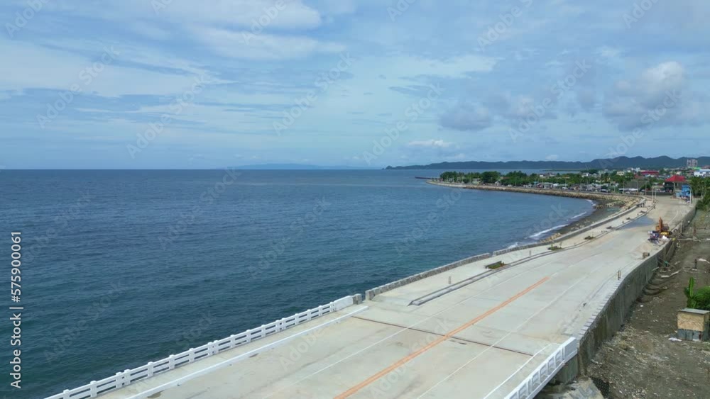 Aerial, Establishing, Drone Shot of Beautiful Ocean, bridge and Seawall facing Coastal Barangay in Virac, Catanduanes, Philippines, Asia Aerial, Establishing, Drone Shot of Beautiful Ocean, bridge and Seawall facing Coastal Barangay in Virac, Catanduanes, Philippines, Asia