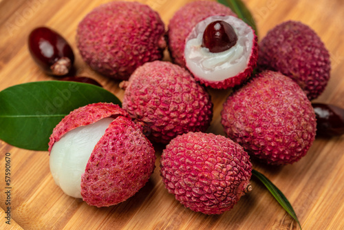 Fresh ripe lychee fruit and peeled lychee on a wooden background. banner, menu, recipe, top view