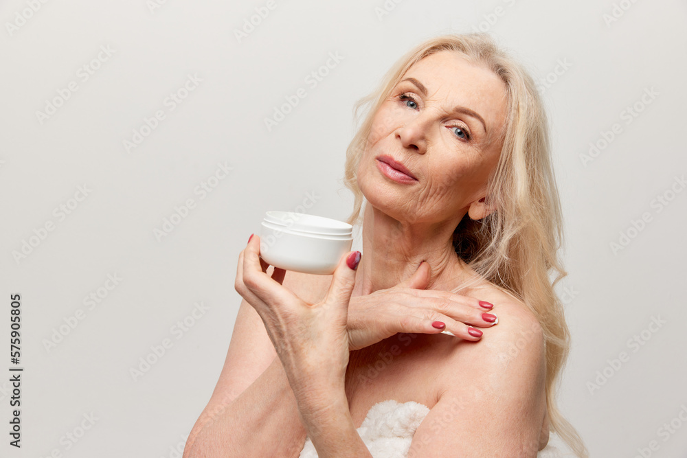 beautiful-middle-aged-woman-with-well-kept-healthy-skin-applying-body