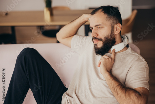Photos A man uses neck massage device to relax sitting on sofa