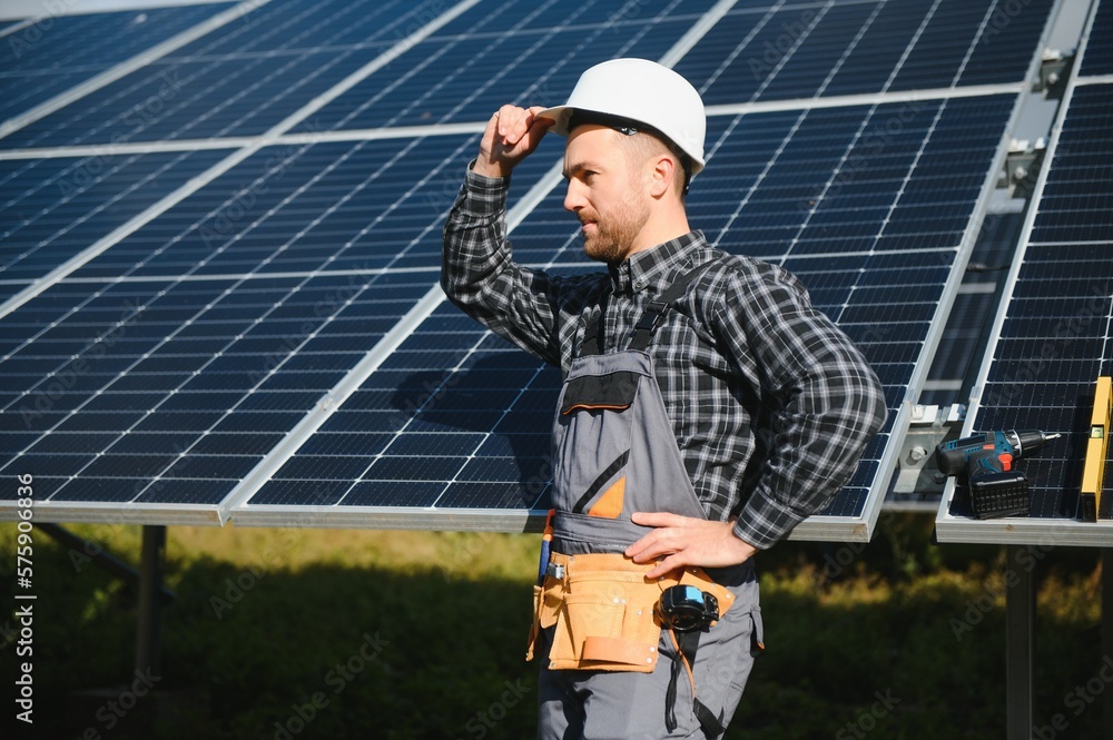 Professional worker installing solar panels on the metal construction, using different equipment, wearing helmet. Innovative solution for energy solving. Use renewable resources. Green energy.