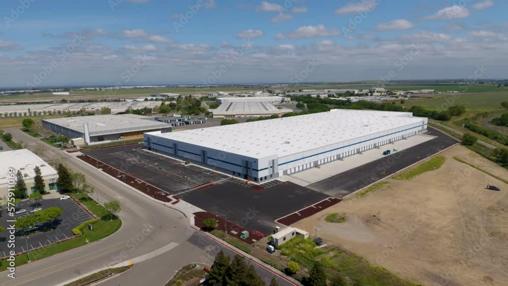High orbiting drone shot of a new warehouse in an industrial area. High orbiting drone shot of a new warehouse in an industrial area.