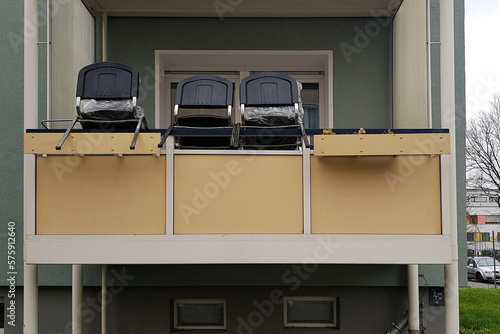 Drei Stühle auf Balkonbrüstung