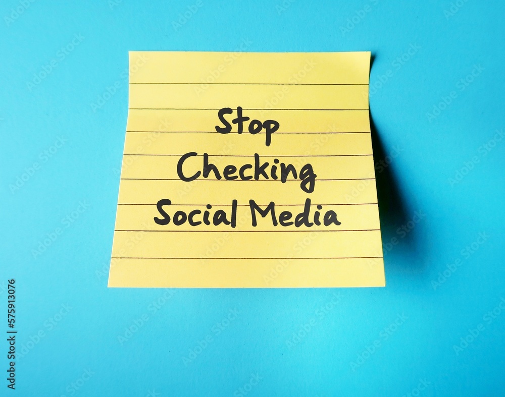 On blue background, handwritten stick note STOP CHECKING SOCIAL MEDIA, decision making to stay away from social media to gain more time to something else, less distracted and less stressed On blue background, handwritten stick note STOP CHECKING SOCIAL MEDIA, decision making to stay away from social media to gain more time to something else, less distracted and less stressed