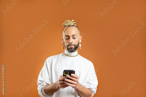 Black Gay Man with bright makeup use smartphone © Andrii