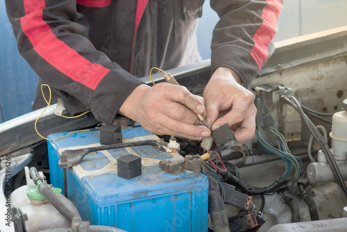 Canvas Print A mechanic is checking the automotive relay to see which part of the electrical system is faulty