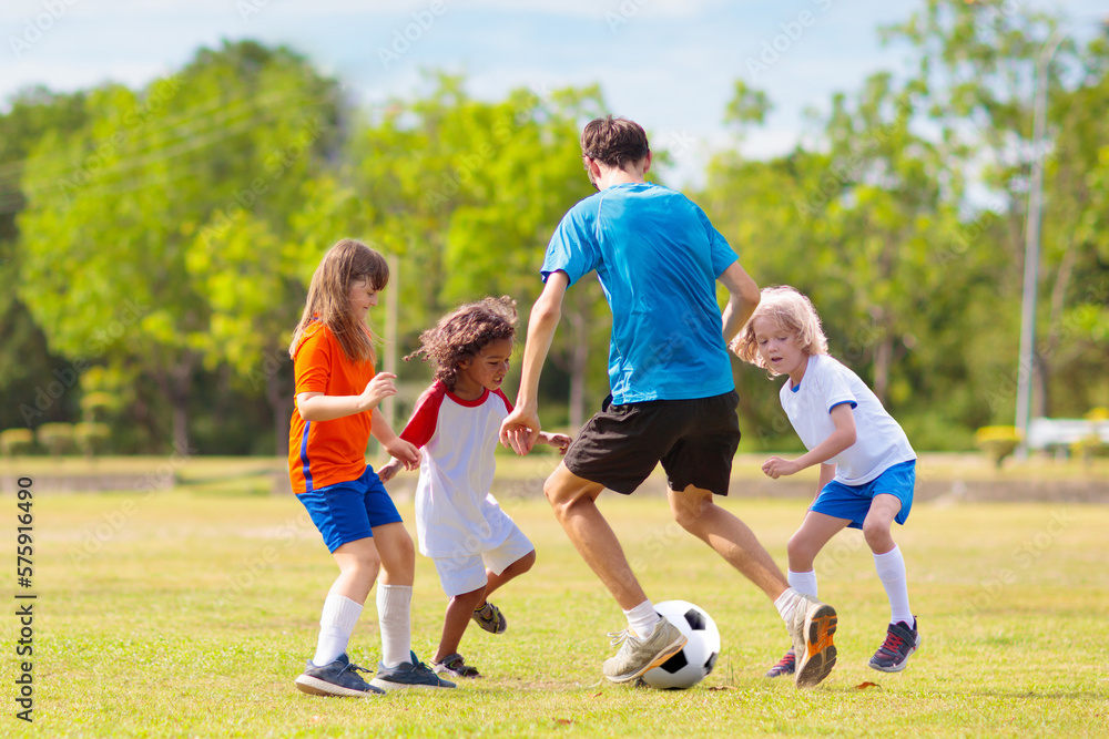 Obraz premium Kids play football. Child at soccer field.