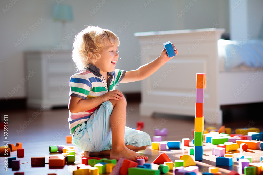Child playing with colorful toy blocks. Kids play. Child playing with colorful toy blocks. Kids play.