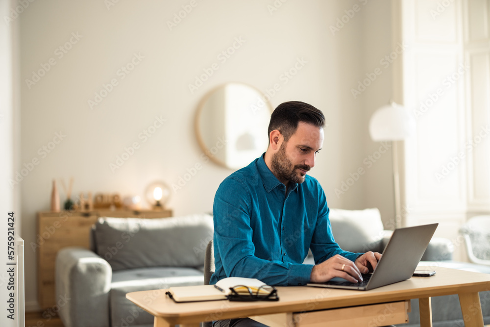 Busy male employee working over the laptop, sitting at the home office. Busy male employee working over the laptop, sitting at the home office.