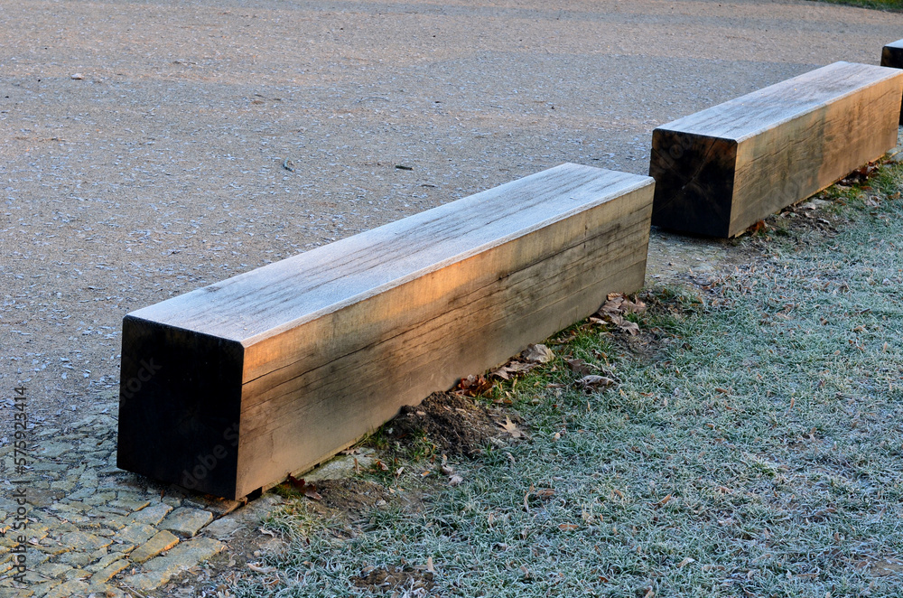 wooden oak prism bench in garden. for better drying of wood, grooves