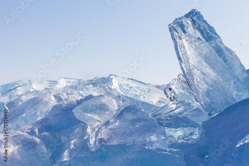 Natural background with a bunch of blocks of transparent blue ice on a cold winter day. The concept of world reserves of fresh water. Scenic winter seascape. Frozen water texture