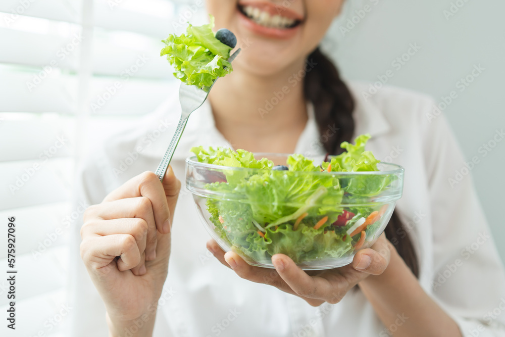 Wellness and healthcare concept, Close-up view happy young woman eat vegan fresh salad.
