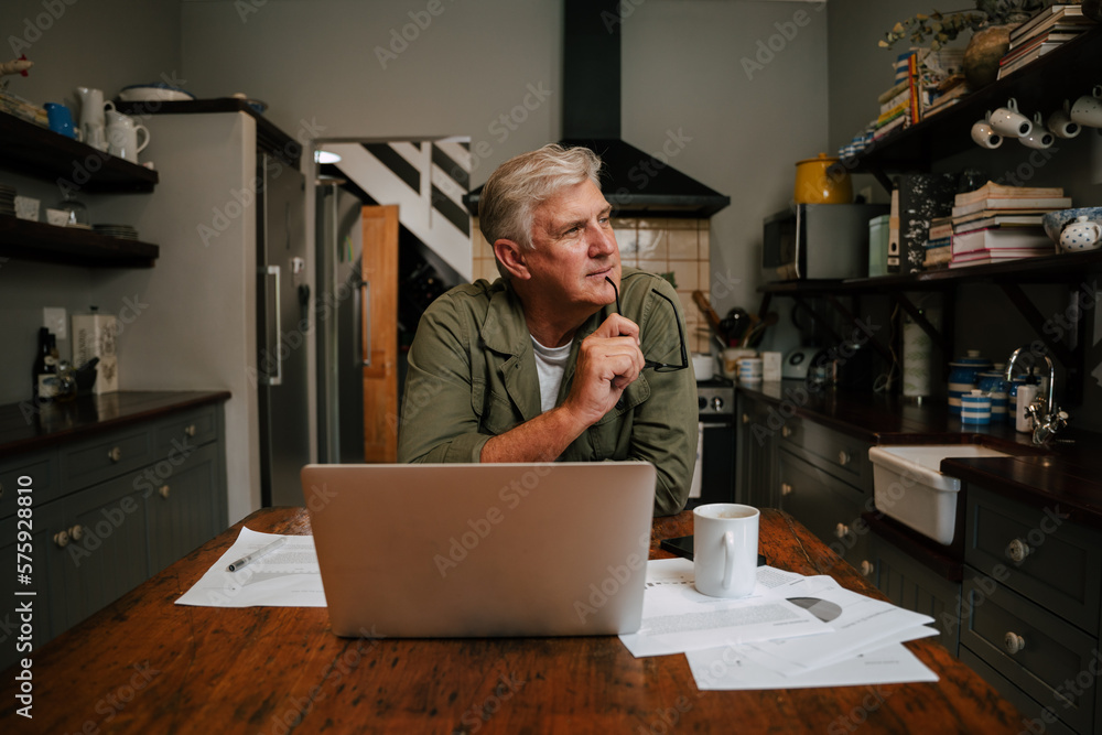 © Prins Productions - Caucasian senior male working at home sitting in kitchen