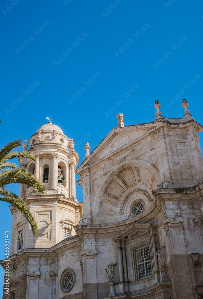 Detail of the Cathedral of La Santa Cruz of Cádiz with bell tower and large window flanked by statues of patron saints and concave shape above, SPAIN