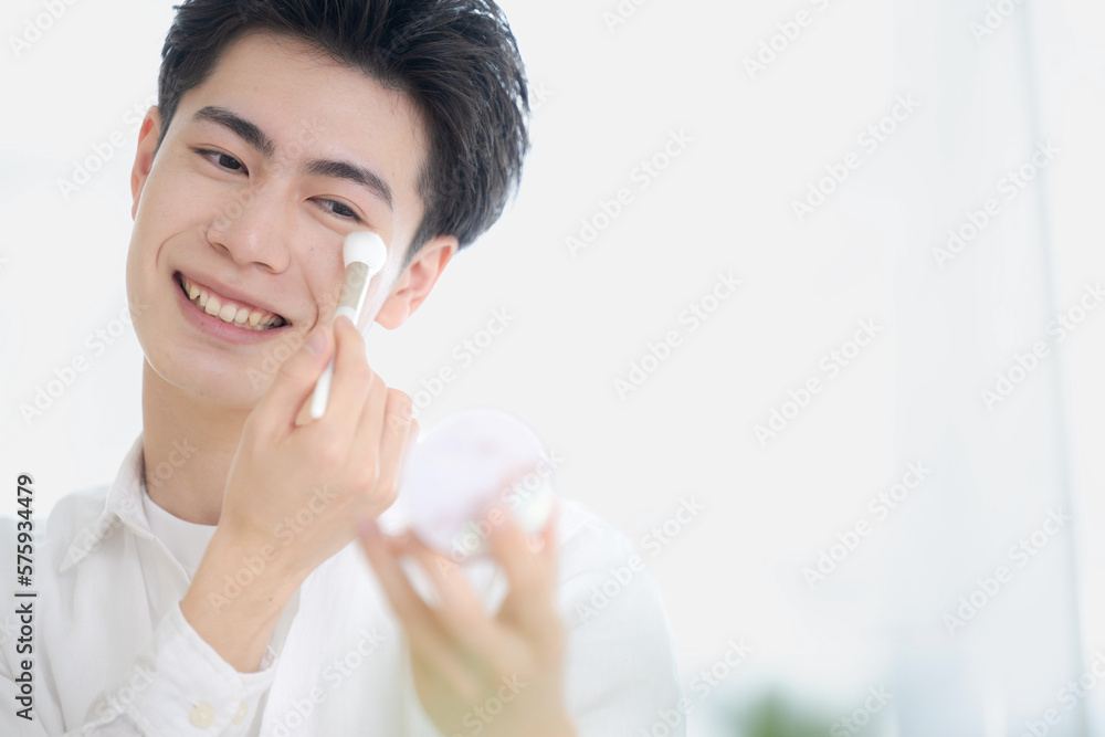 美容イメージで使いやすいメイクをする美しい若い男性 笑顔 美容イメージで使いやすいメイクをする美しい若い男性 笑顔