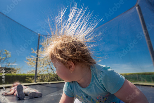 Obraz na płótnie Electrified girl's hair whos jumping on a trampoline. w salonie