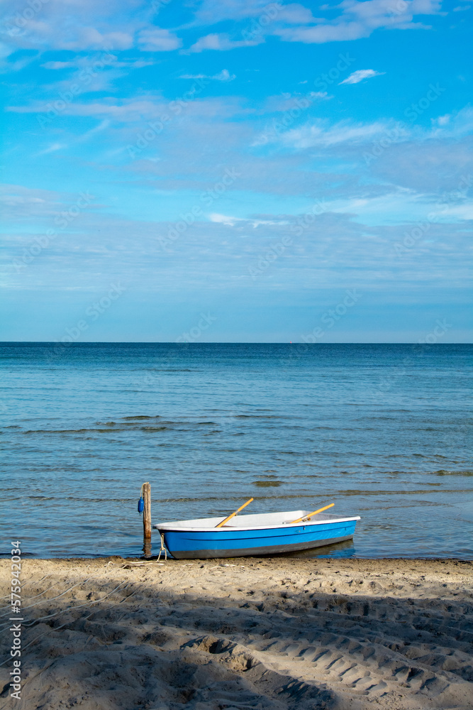 Small boat on the beach in front of the open sea Small boat on the beach in front of the open sea