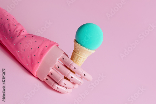 Wooden hand model, waffle cone in it and ocean blue ball, creative aesthetic concept, summer holidays, blue moon flavor ice cream idea