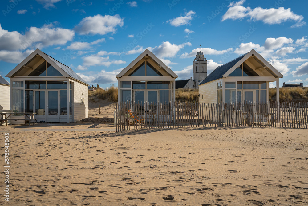 Small beach houses and the tower of white church at the seaside resort Katwijk aan Zee, The Netherlands Small beach houses and the tower of white church at the seaside resort Katwijk aan Zee, The Netherlands