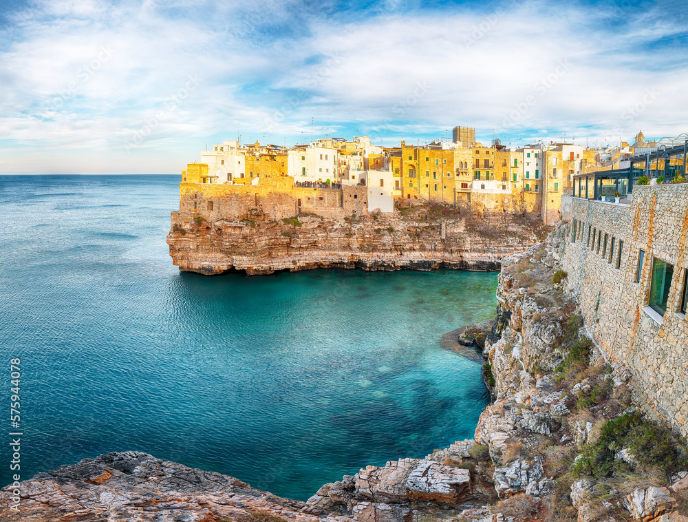 Amazing view on Polignano a Mare village on the rocks at sunset.
