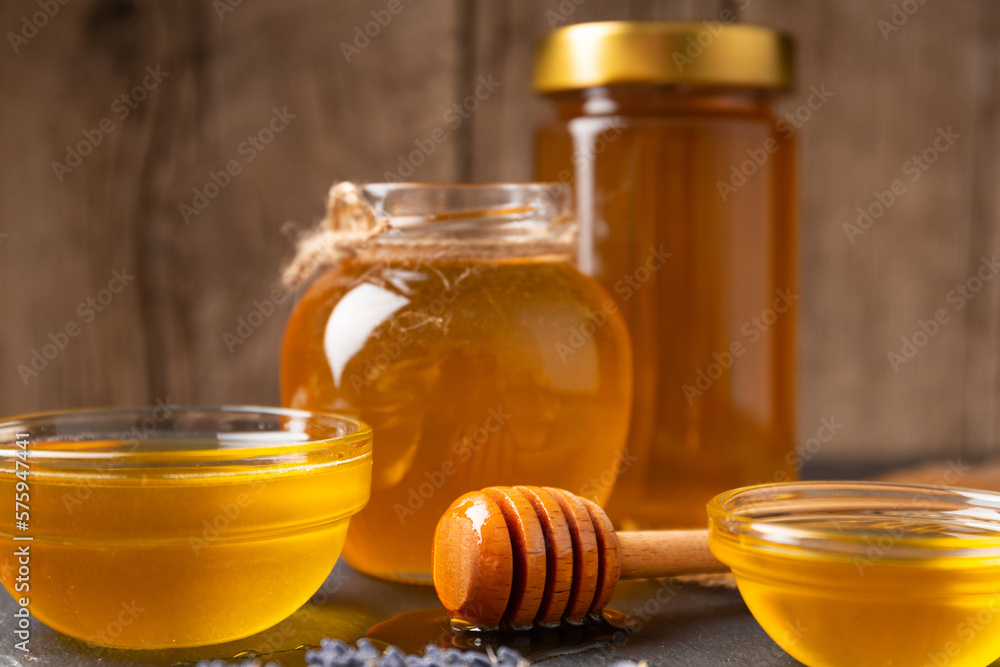 Honey in jars and bowls on a wooden background Honey in jars and bowls on a wooden background