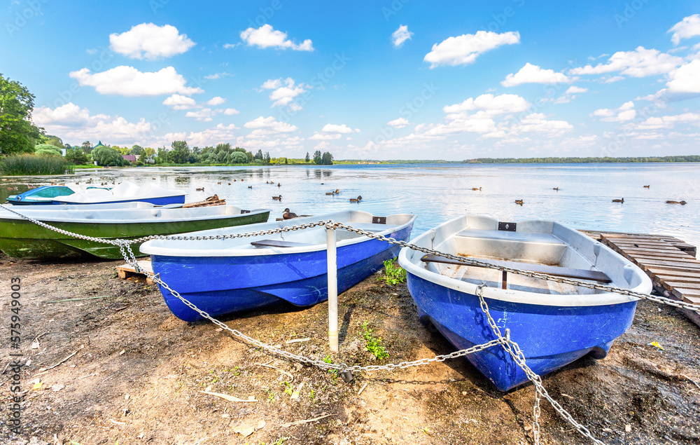 Plastic pleasure boats are moored on the shore of the lake