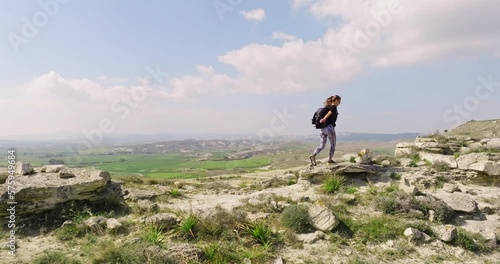 Aerial view Caucasian woman with a backpack climbs the mountains. Haikin in a beautiful landscape. Active recreation and outdoor sports. High quality 4k footage photo