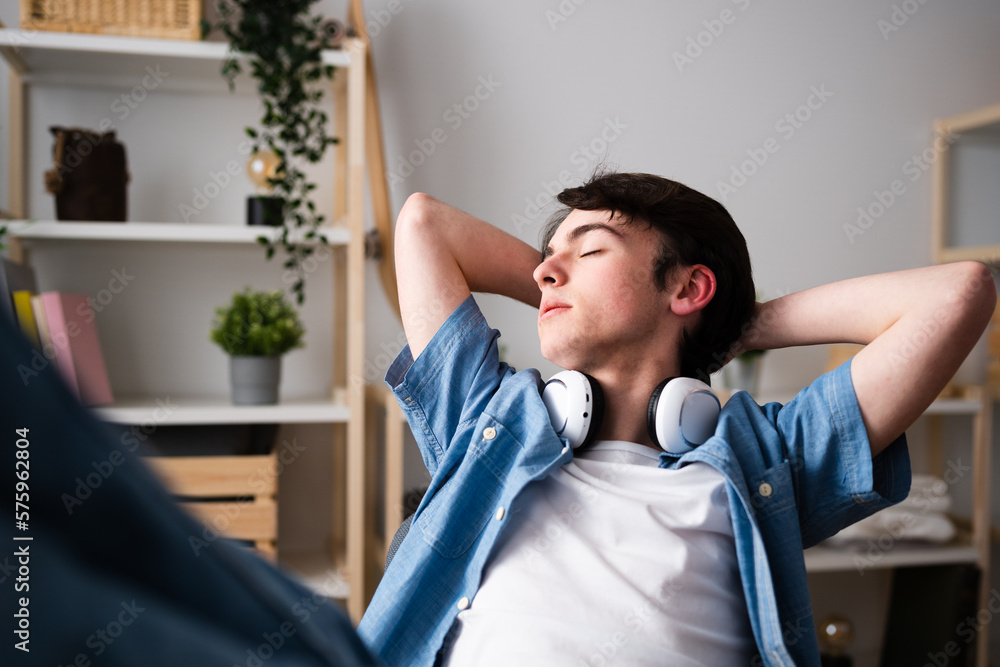 Fototapeta premium Teenager boy relaxing feet on desk